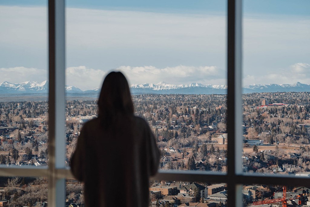 a person is looking out a window at a city