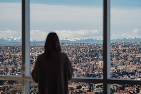 a person is looking out a window at a city