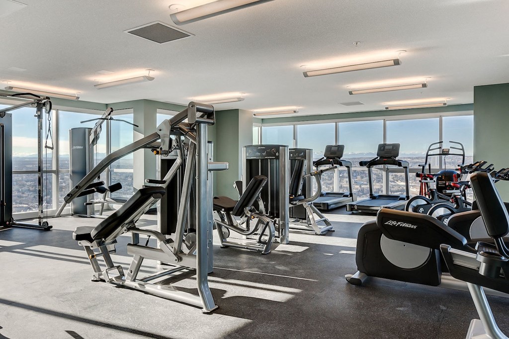 a gym with cardio equipment and a view of the city