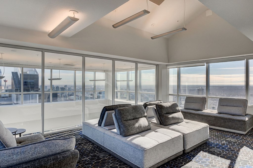 a living room with a couch and chairs in front of windows