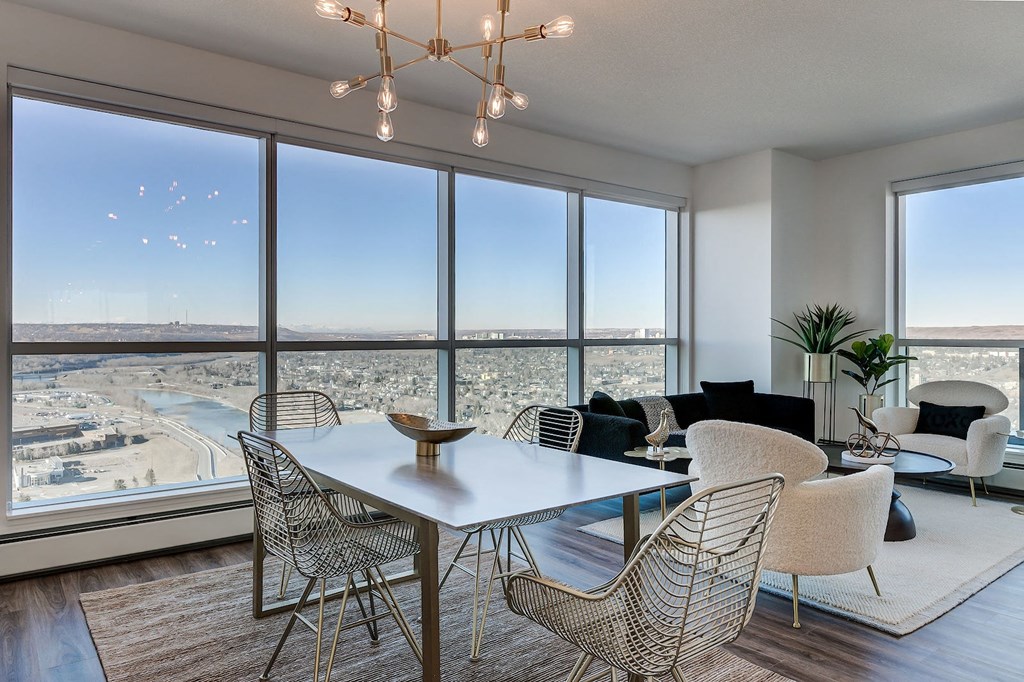 a dining room with a view of a city and a table and chairs