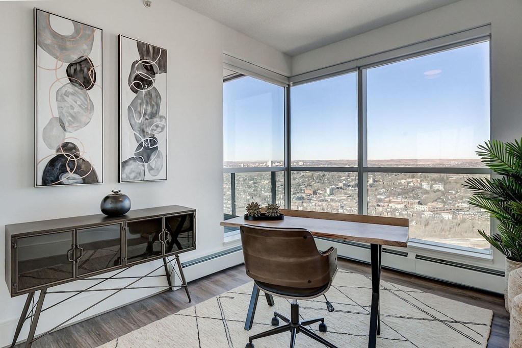 an office with a view of the city and a desk with a chair