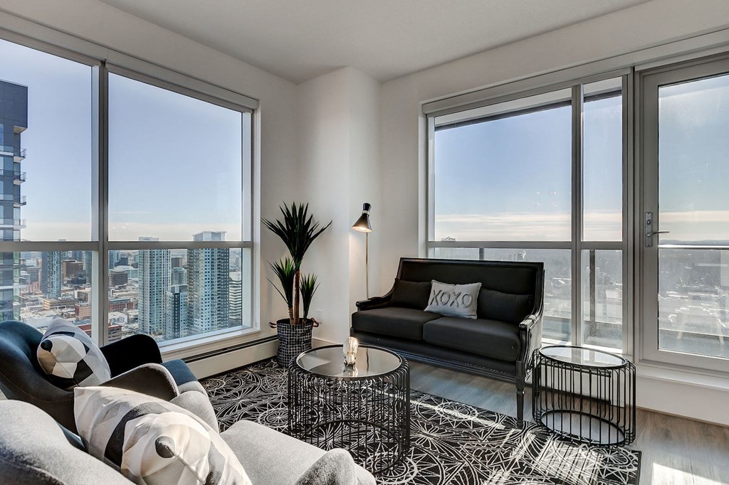 a living room with large windows and a black couch