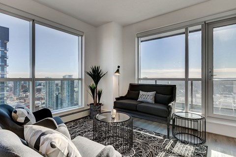 a living room with large windows and a black couch