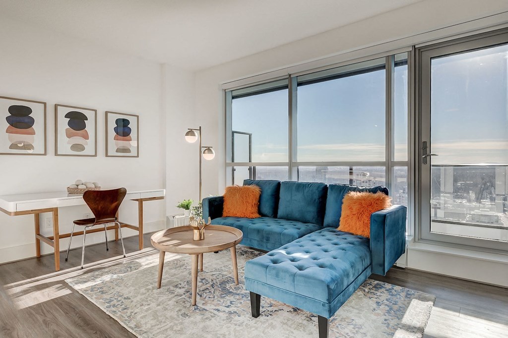 a living room with a blue couch and a large window