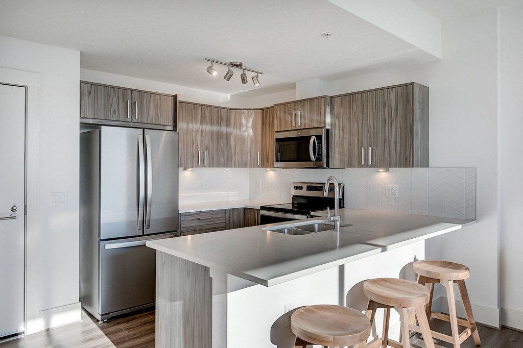 a kitchen with stainless steel appliances and a island with three stools