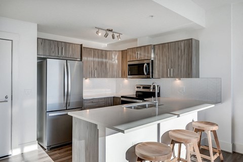 a kitchen with stainless steel appliances and a island with three stools