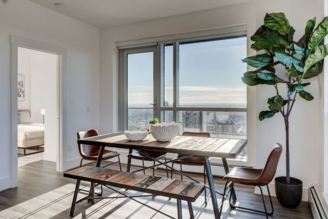 a dining room with a table and chairs and a large window