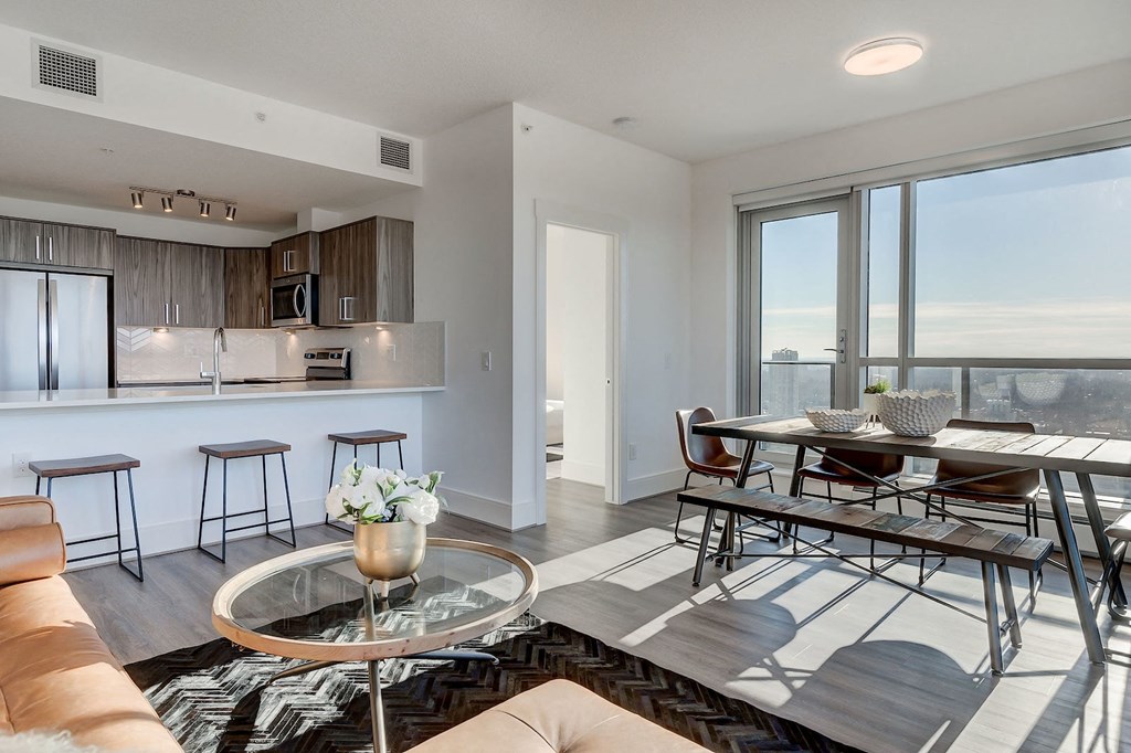 a living room with a kitchen and a table and chairs