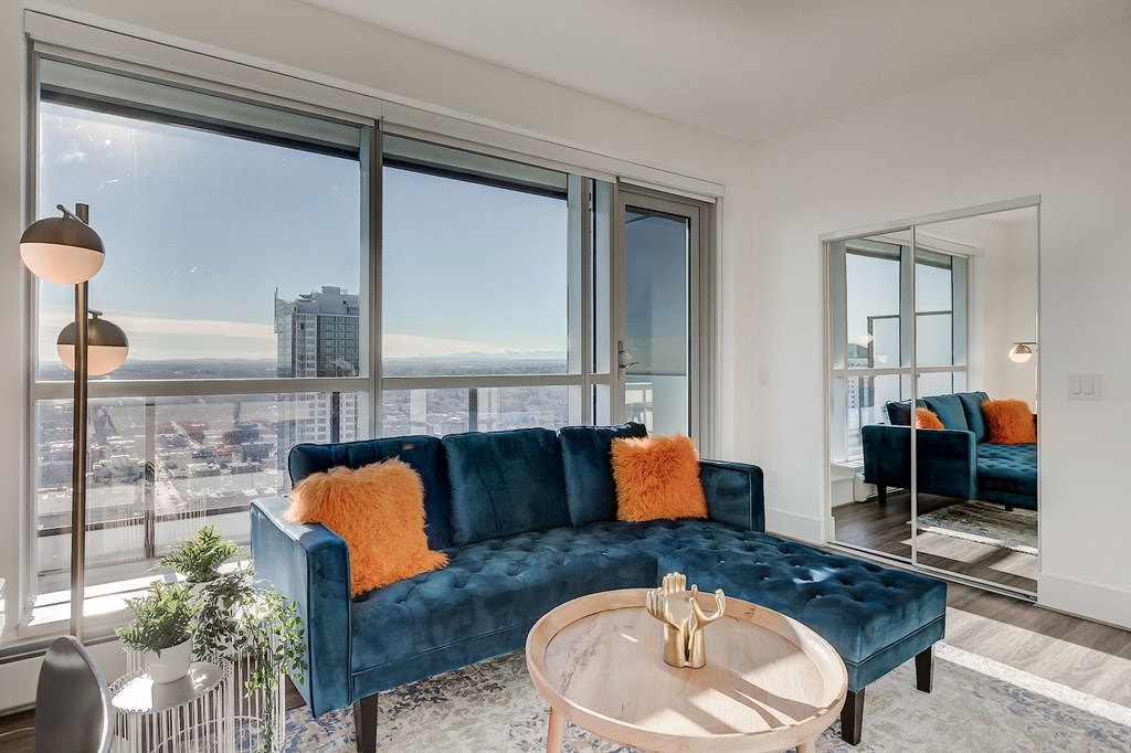 a living room with a blue couch and a large window