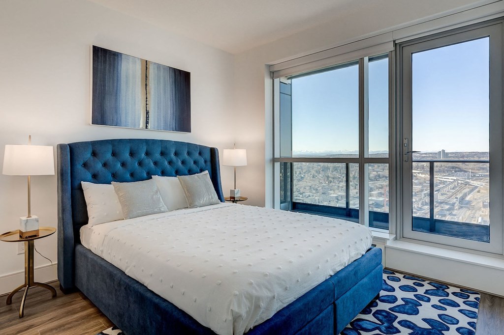 a bedroom with a bed and a large window