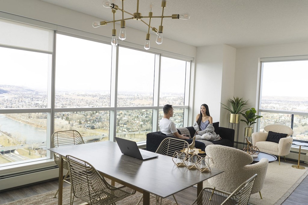two people sitting on a couch in a living room with a table