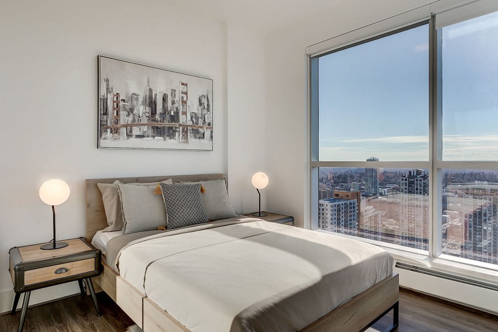 a bedroom with a large window and a bed