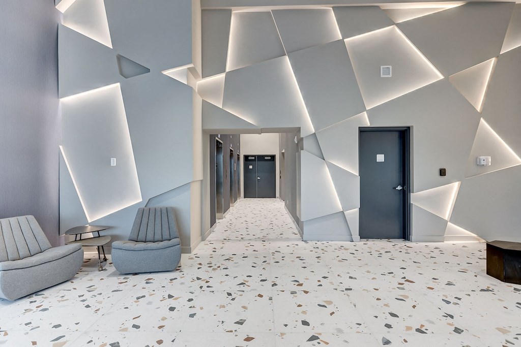 a lobby with a white tile floor and chairs and a blue door
