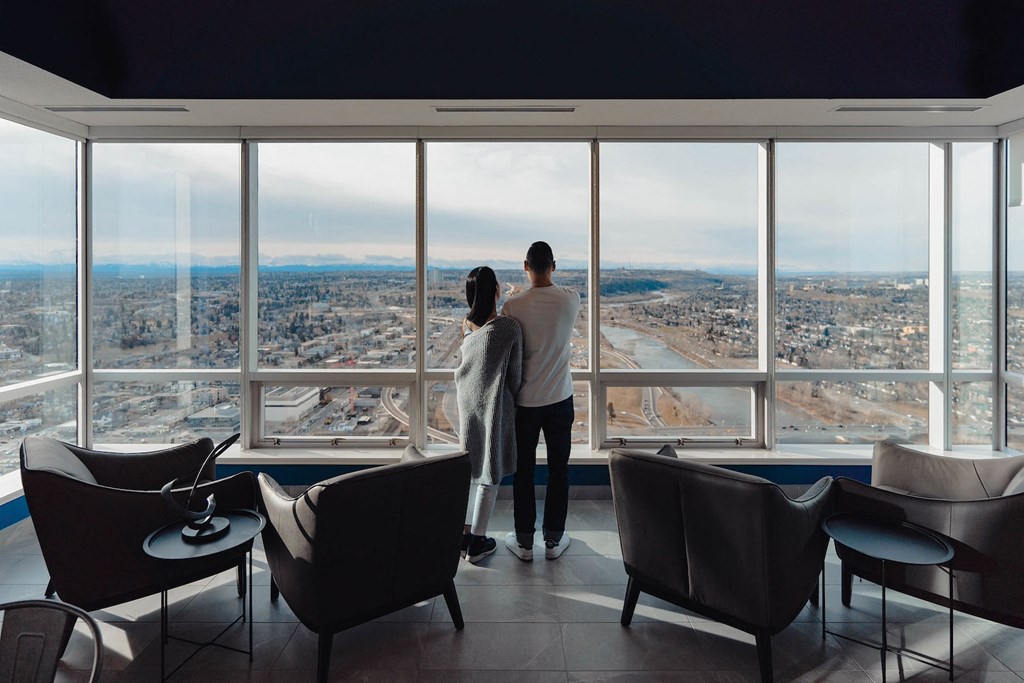 a man and a woman looking out the window of a skyscraper