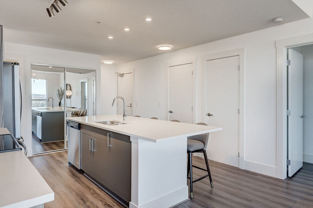 a kitchen with a white counter top and a sink