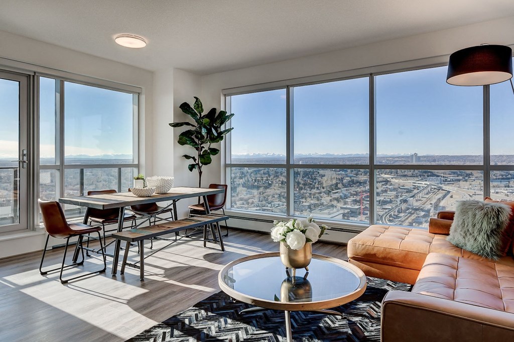 a living room with a view of a city and a table and chairs