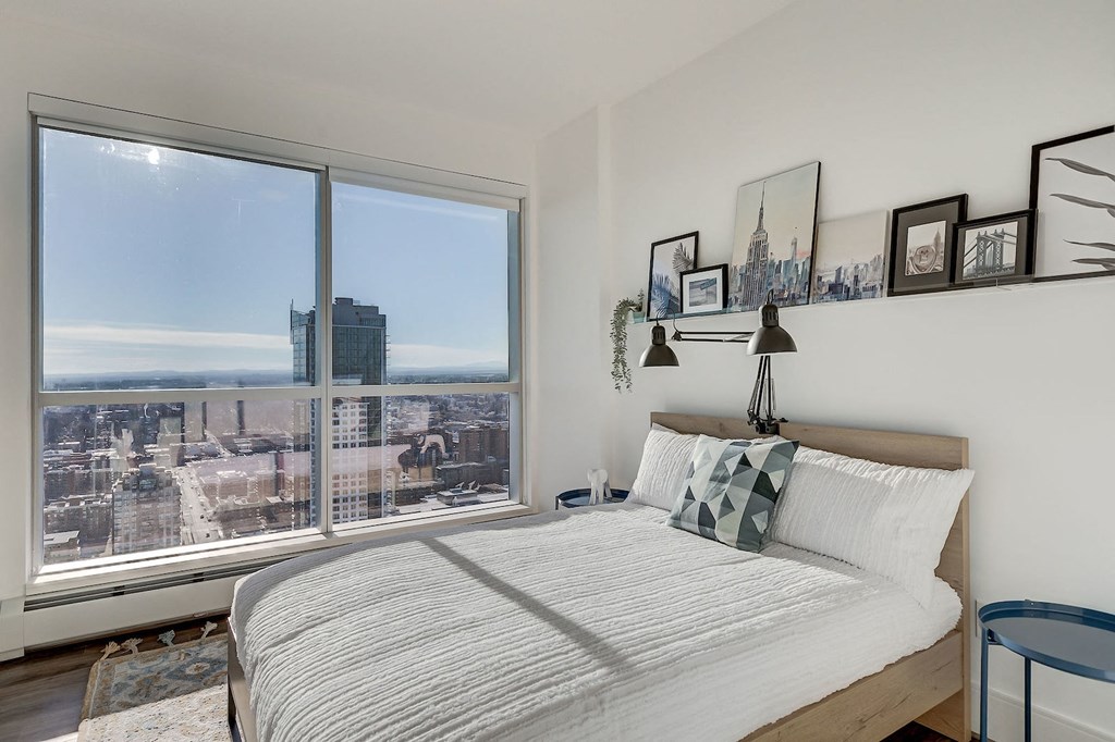 a bedroom with a bed and a large window