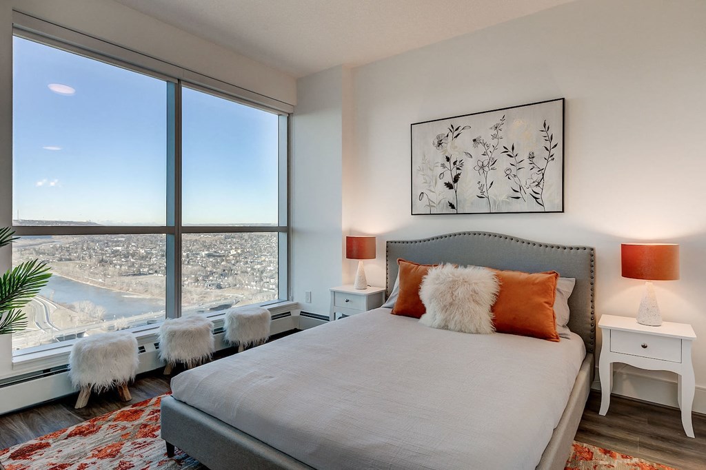 a bedroom with a bed and a large window