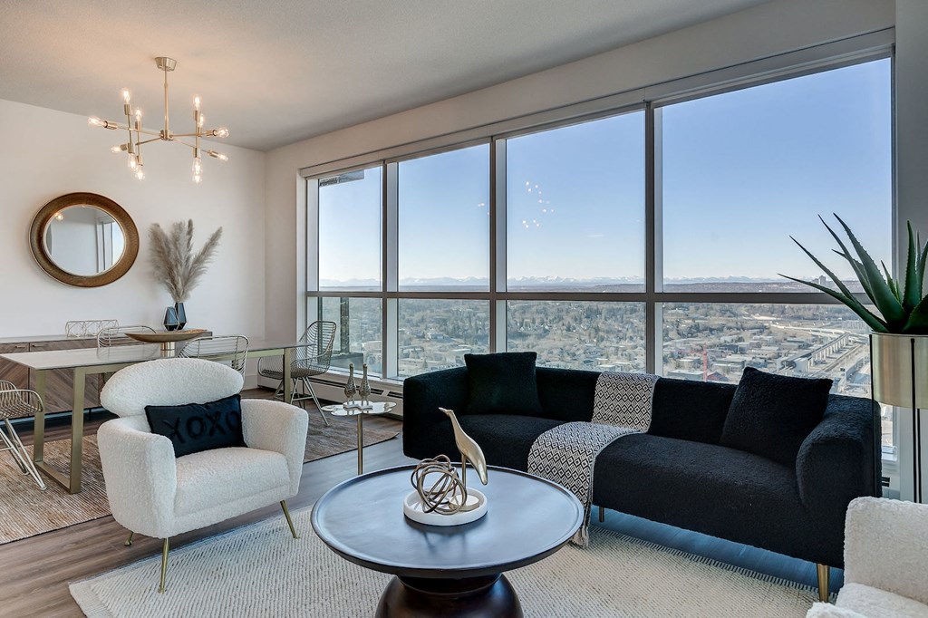 a living room with a view of a city and a table and chairs