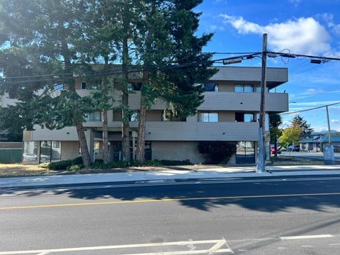 A street view of a multi-story building with a clear sky above.