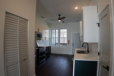 A kitchen with a white fridge and black cabinets.