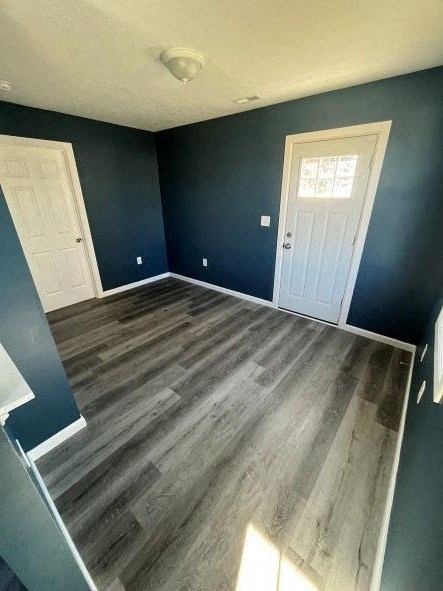 A room with a wooden floor and two white doors.