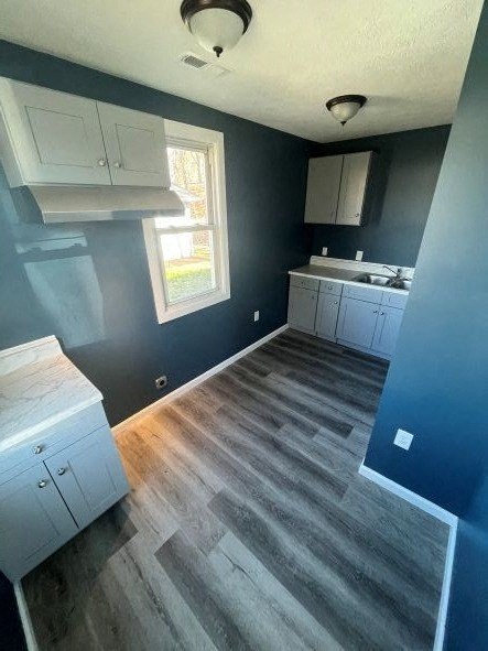 A kitchen with white cabinets and a window.