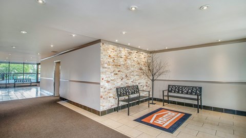 A hallway with a stone wall and a bench.