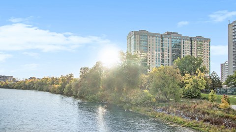 A river flows through a city with trees and buildings on the side.