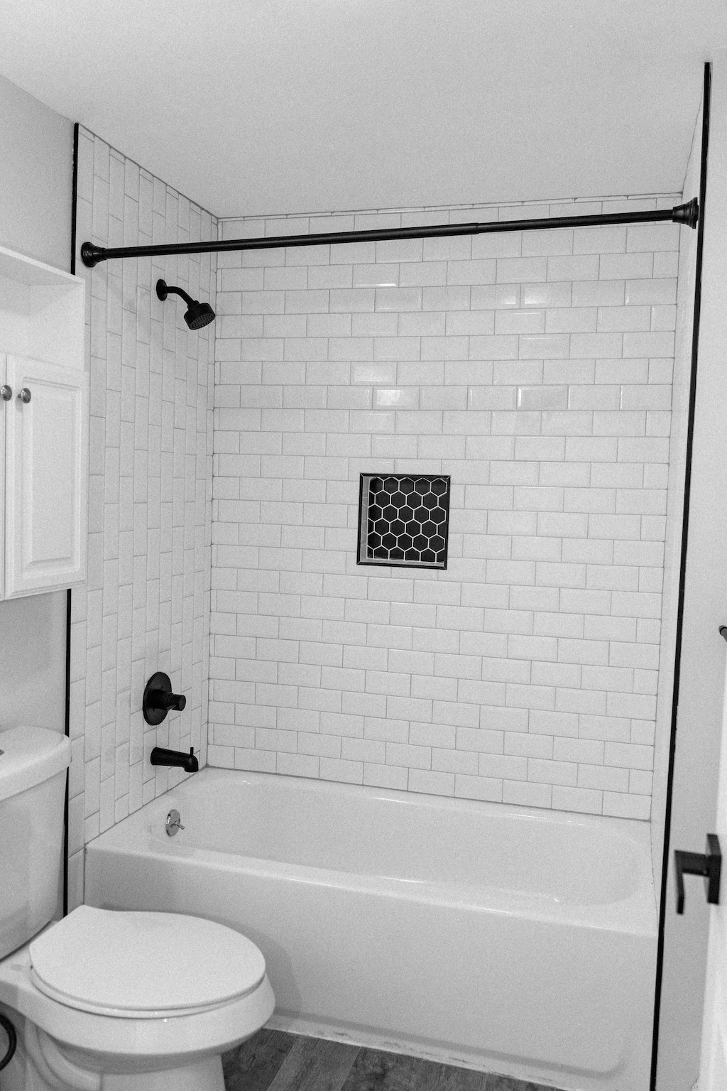 a black and white bathroom with a tub and a toilet
