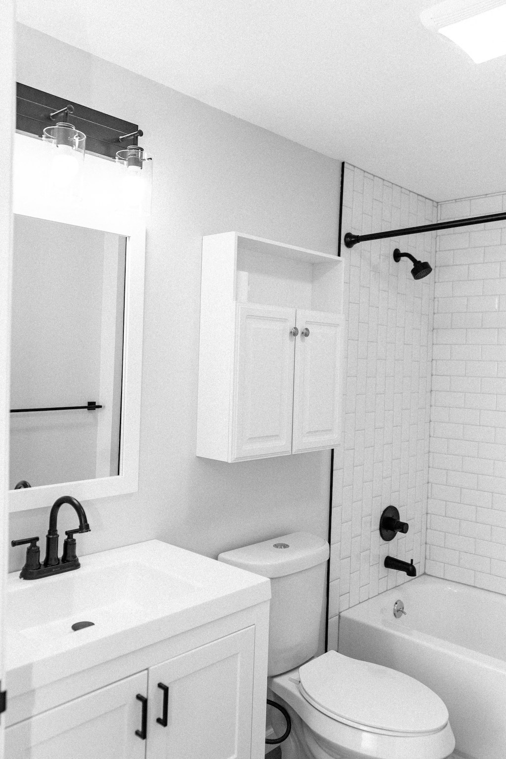 a black and white bathroom with a white toilet and sink