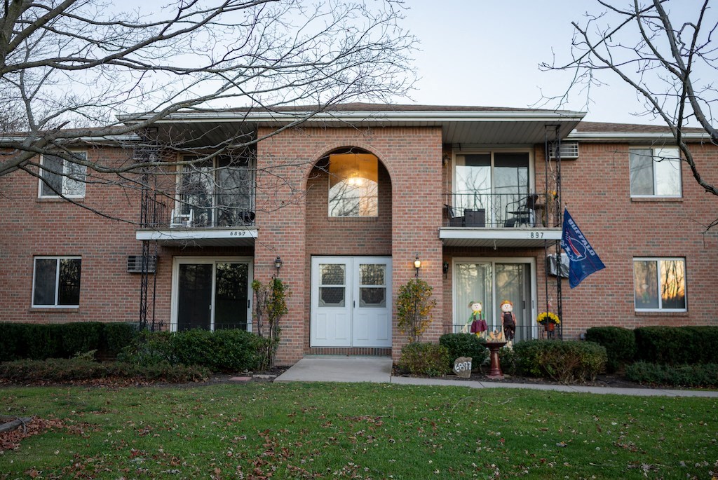 the front of a brick apartment building with a white door