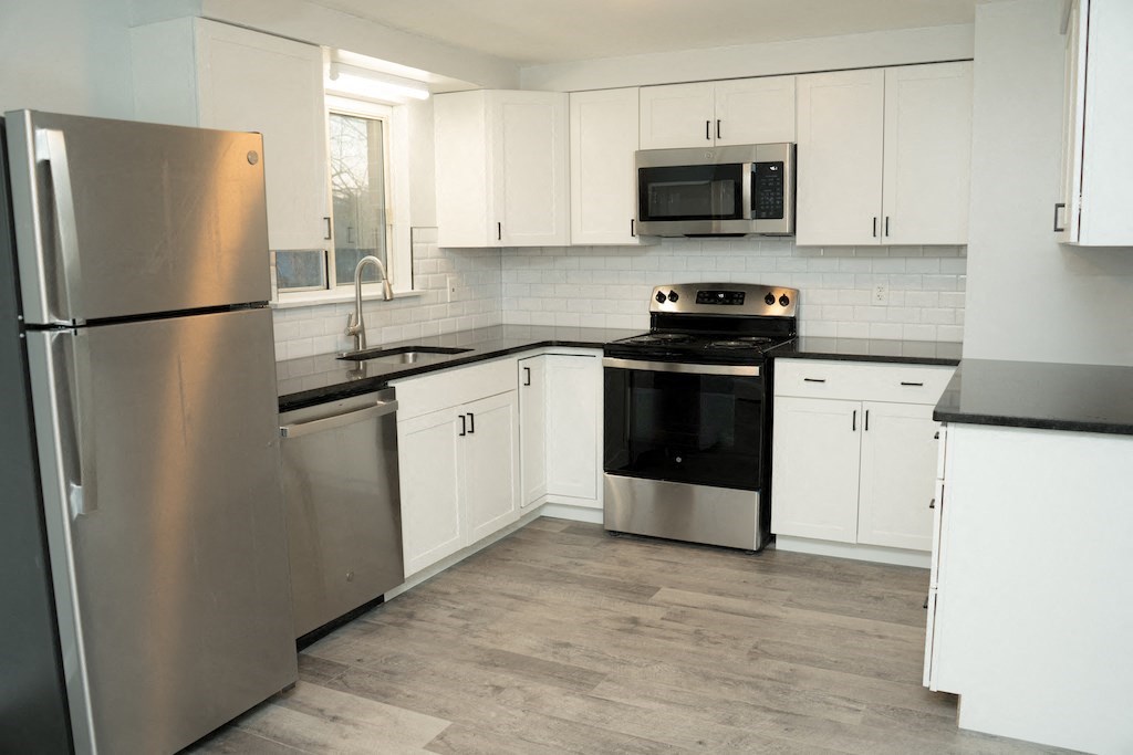 a kitchen with stainless steel appliances and white cabinets