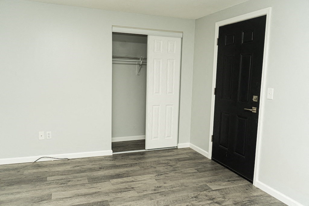 an empty room with a closet and a black door