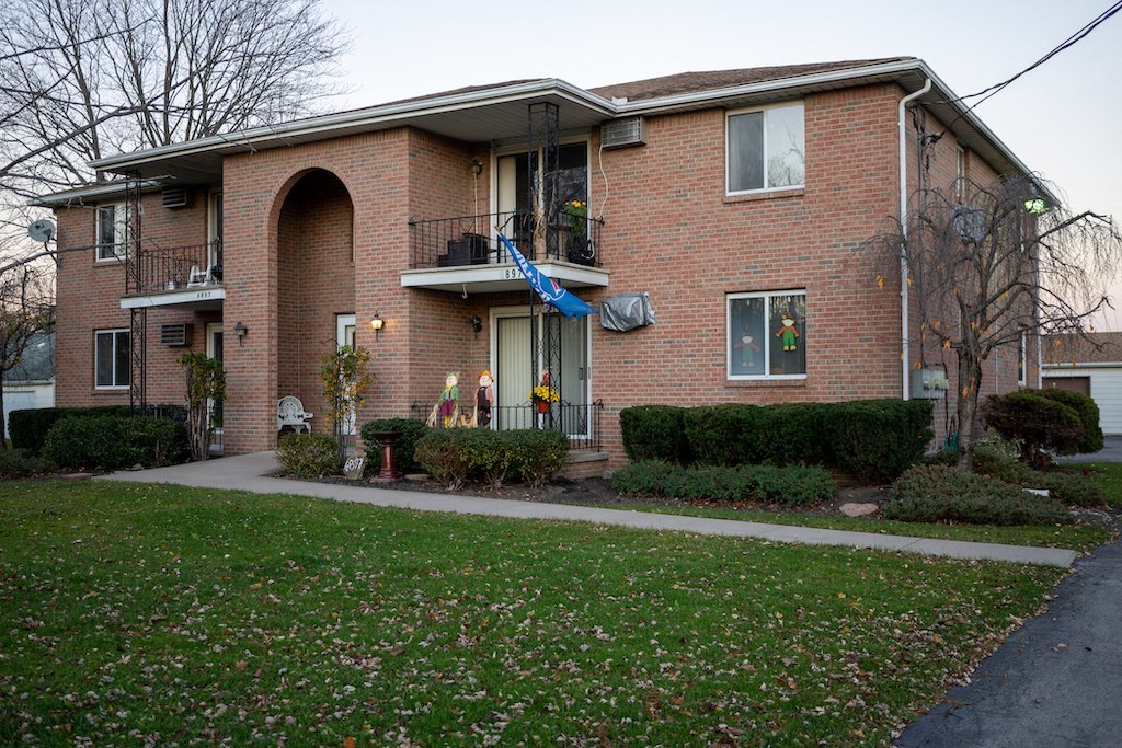 a brick house with a yard in front of it