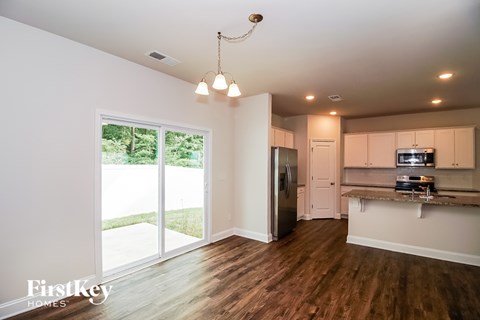 A kitchen with wooden floors and a refrigerator.