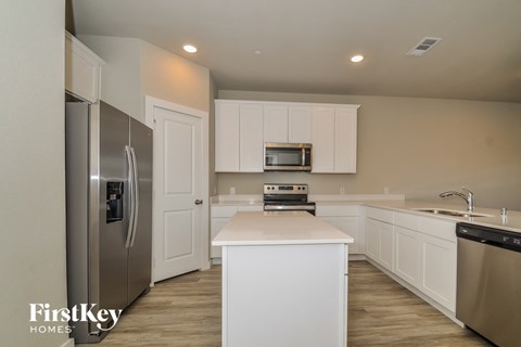 a white kitchen with stainless steel appliances and white cabinets
