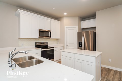A kitchen with a stainless steel refrigerator and a white countertop.