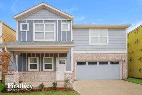 a blue house with a garage door in front of it