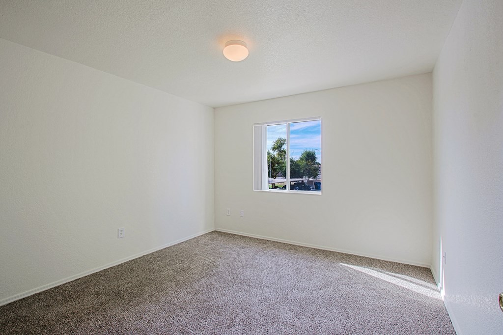 an empty room with carpet and a window