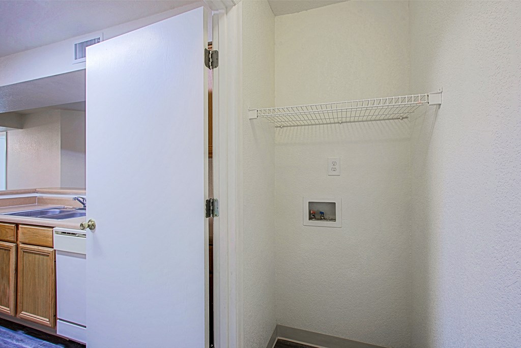 an empty kitchen with a refrigerator and a door to a closet