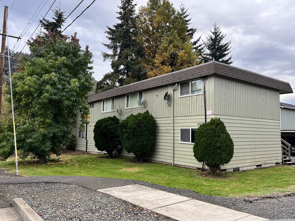a white house with green grass and trees