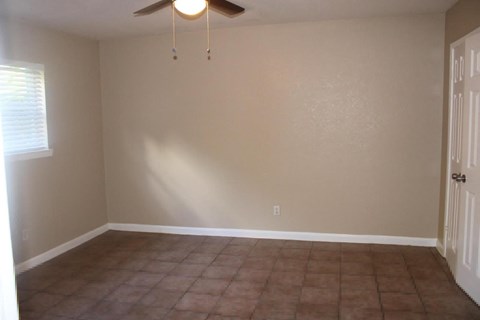 a empty living room with a ceiling fan