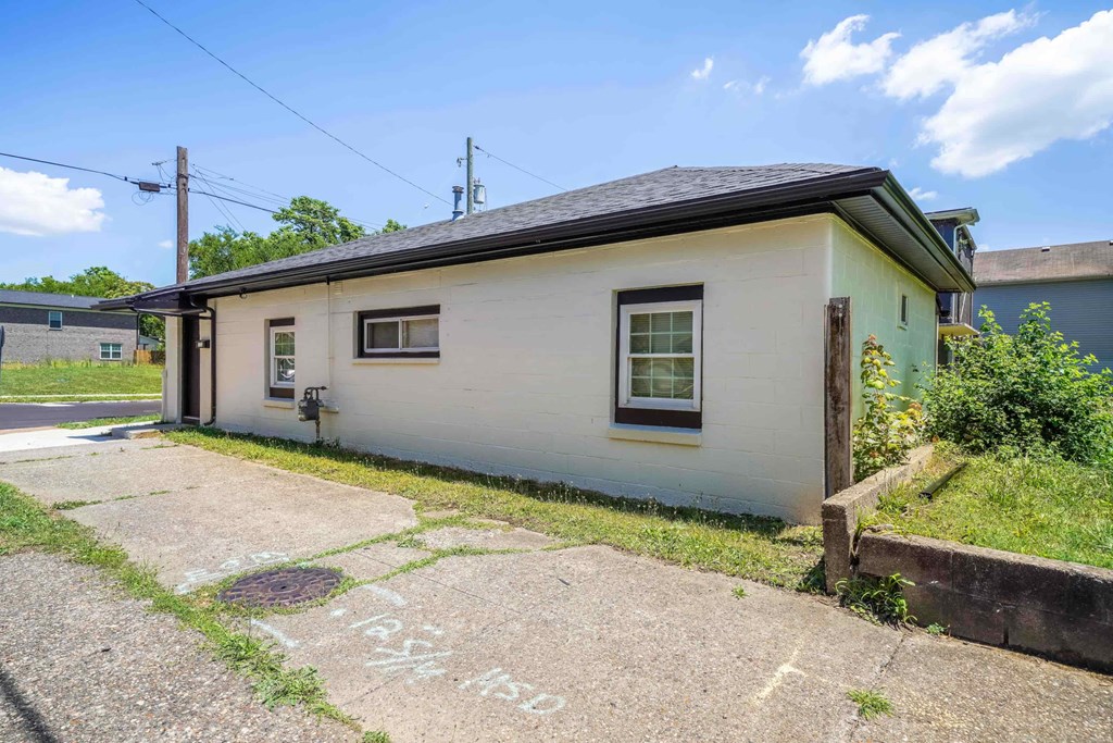 a small white house with a sidewalk in front of it