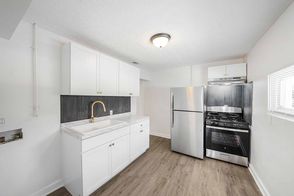 a kitchen with white cabinets and a stainless steel refrigerator