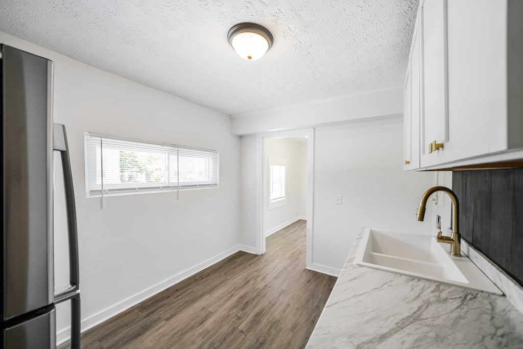 a kitchen with a sink and a refrigerator and a window