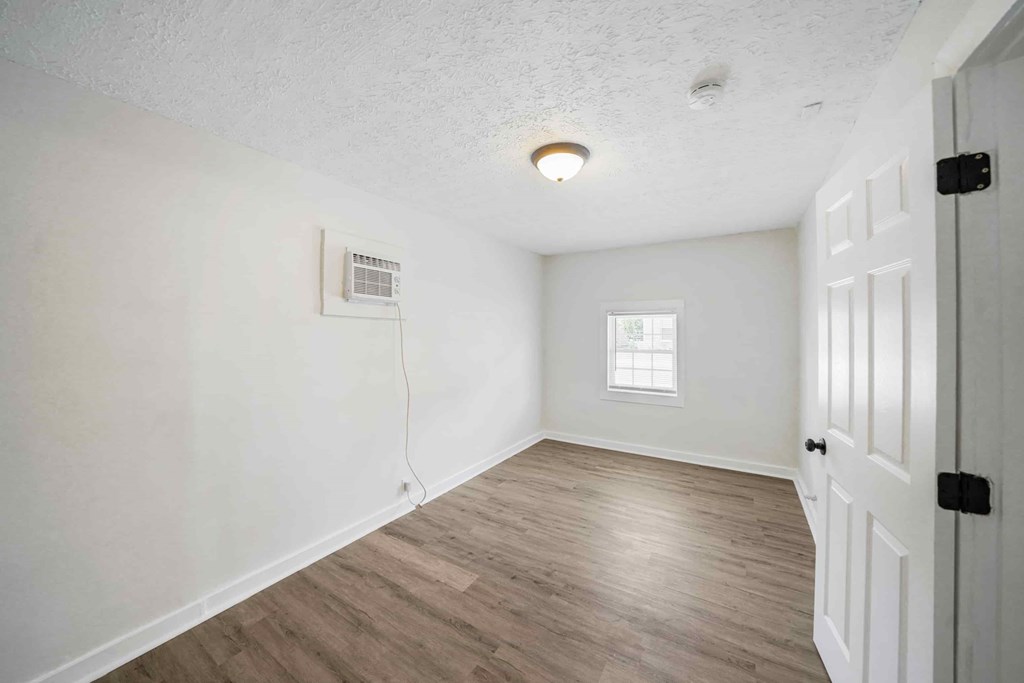 an empty living room with white walls and a white door