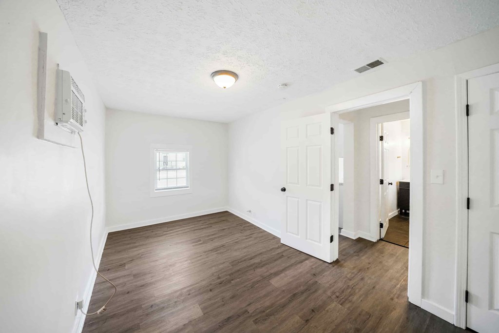 an empty living room with white walls and wood floors