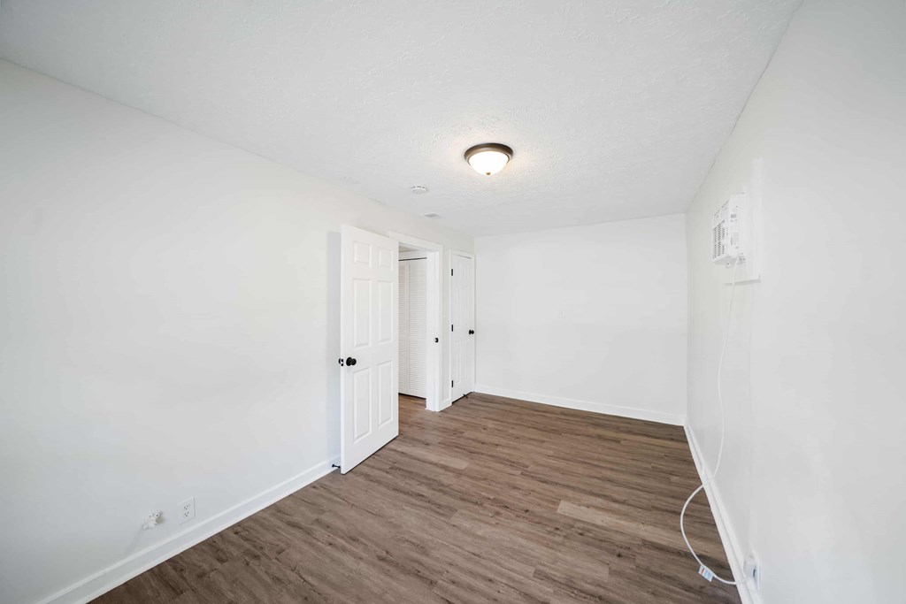 a living room with a hard wood floor and white walls